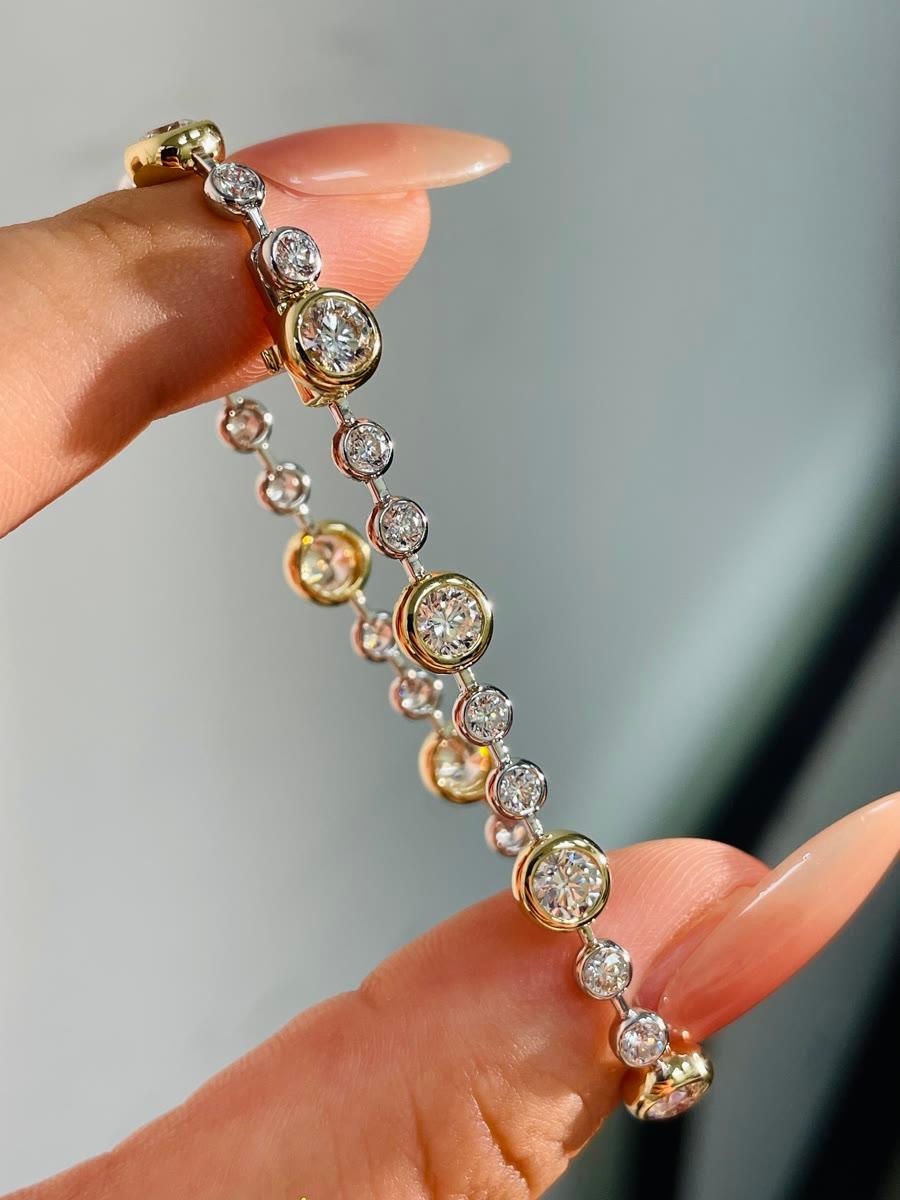 Ein fertiges goldenes Tennisarmband mit zargengefassten runden Diamanten