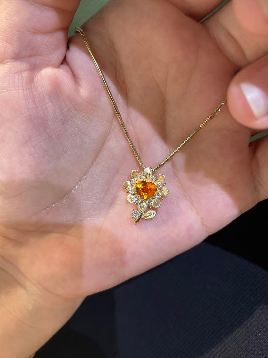 Ein fertiger Blumenanhänger als Kette mit herzförmigem orangefarbenem Mittelstein an einer Box-Kette